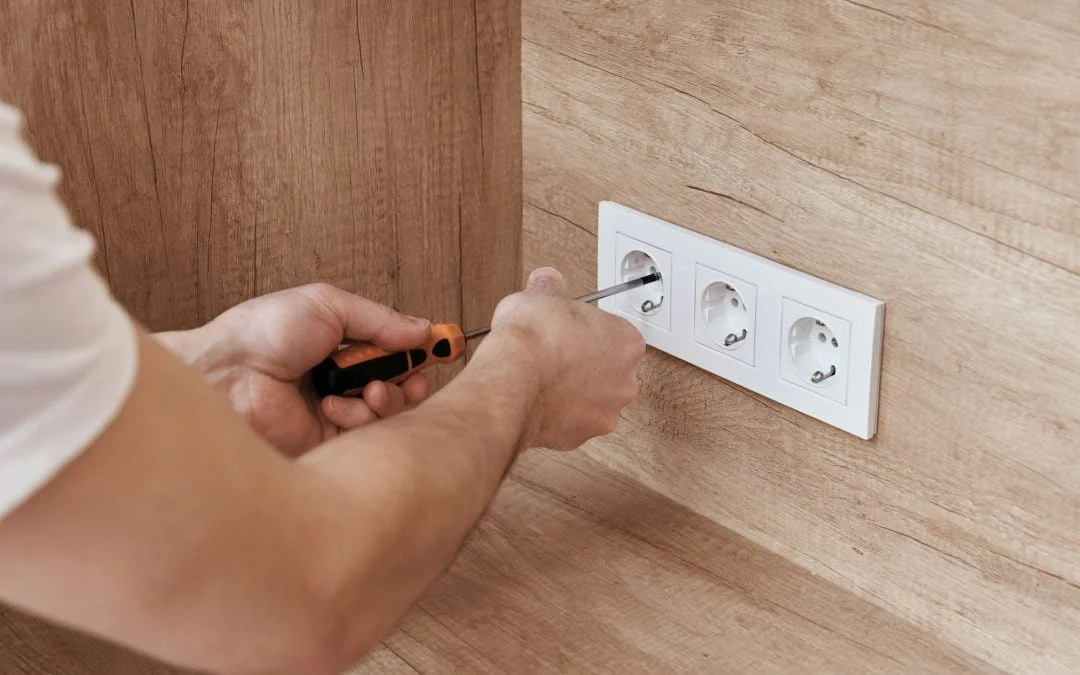 Electrician installing socket in the kitchen